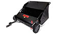 Image of a black lawn sweeper with red and yellow accents. It features two wheels and a bag for collecting lawn debris. The handle is visible, and the overall design suggests it is used for yard maintenance tasks.
