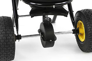 Close-up image of the wheels of a black lawn mower. The front wheel is smaller and centrally located, while the two larger rear wheels have yellow rims. The background is white.