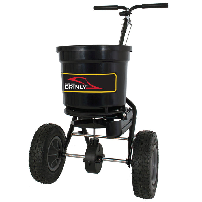 The Brinly Parts 50 LB. Push Spreader with Side Deflector & Hopper Cover (P20-500BHDF-A) features large pneumatic tires, a handlebar, and a round hopper, shown from the front against a white background.