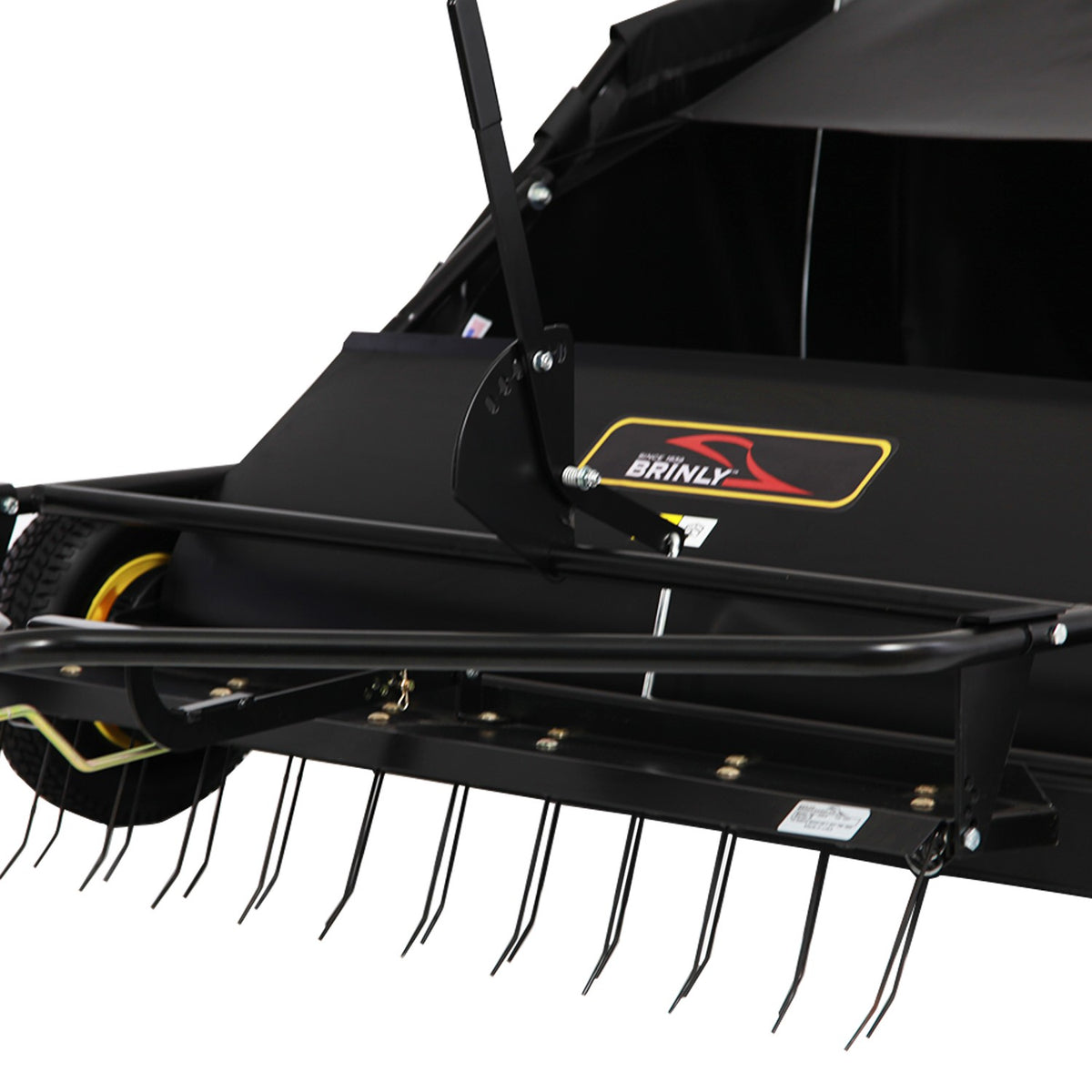 Close-up of a Brinly Parts 42″ Lawn Sweeper with Dethatcher (STS-42BHDK-A), featuring metal tines, visible collection bin and wheels, designed for efficient lawn debris removal.