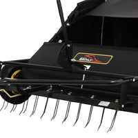Close-up of a Brinly Parts 42″ Lawn Sweeper with Dethatcher (STS-42BHDK-A), featuring metal tines, visible collection bin and wheels, designed for efficient lawn debris removal.