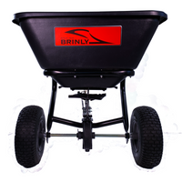 The Brinly Parts 125 Lb. Tow-Behind Broadcast Spreader (BS26BH) features large treaded wheels and a rust-proof hopper with a red Brinly logo, shown from the front on a white background.
