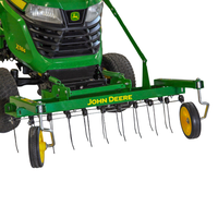 A close-up of a John Deere 38" Front-Mount Dethatcher (LP48004) attached to the front of a John Deere X300 riding lawn mower, highlighting its sturdy tines and yellow wheels on a white background—ideal for efficient lawn maintenance.
