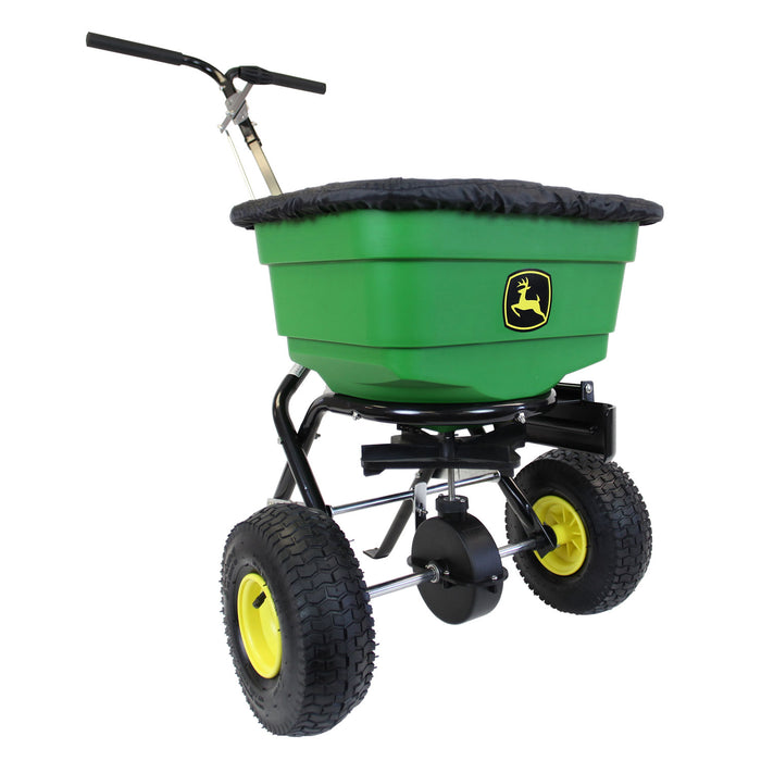 The John Deere All-Season Push Broadcast Spreader (LP31340L/LP31340) features a durable poly hopper with the iconic deer logo, an ergonomic split handle, large wheels with yellow rims, and a protective fabric cover.