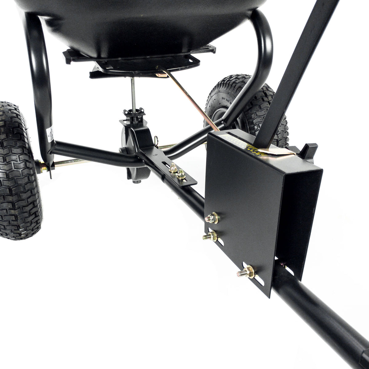 A close-up of the Brinly Parts 125 Lb. Tow-Behind Broadcast Spreader | BS26BH reveals a black metal frame with wheels and a rectangular box, ideal for gardening tasks like lawn fertilization. It features bolts, a connecting rod, and a rust-proof polyethylene hopper.