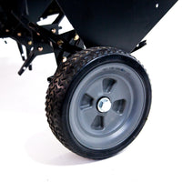 Close-up of a black wheel on the Brinly Parts 48″ Tow-Behind Plug Aerator (PA-482BH), featuring a gray hub and textured rubber tire against a white background, with steel tines to enhance soil structure and promote healthy roots.