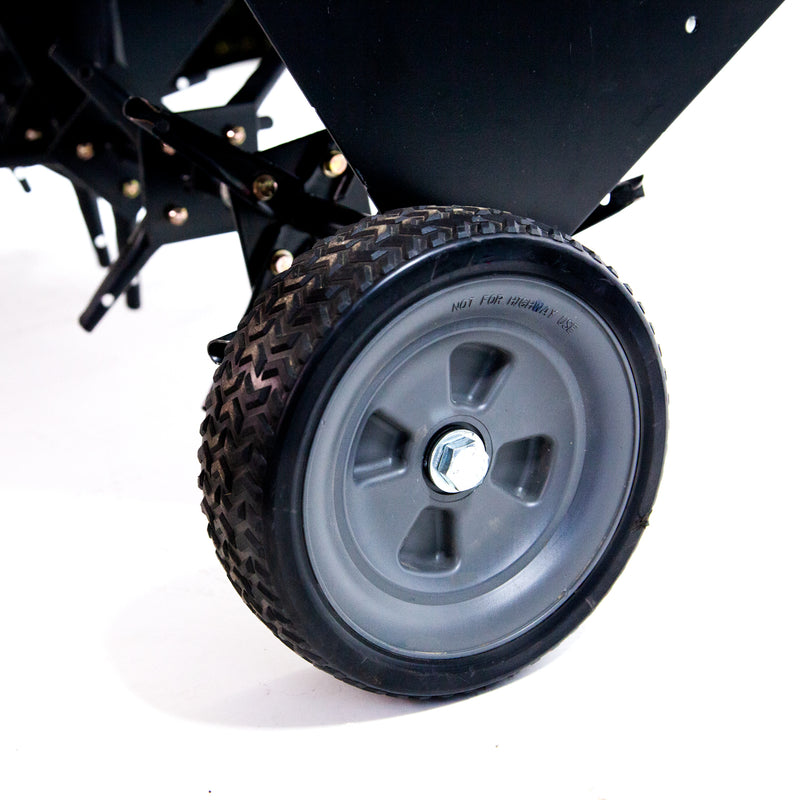 Close-up of a black wheel on the Brinly Parts 48″ Tow-Behind Plug Aerator (PA-482BH), featuring a gray hub and textured rubber tire against a white background, with steel tines to enhance soil structure and promote healthy roots.