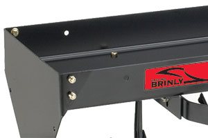 Close-up of a black metal bracket featuring a red sticker with the word BRINLY and a stylized logo. The bracket has visible bolts and is part of a structure with an adjoining curved black metal piece.