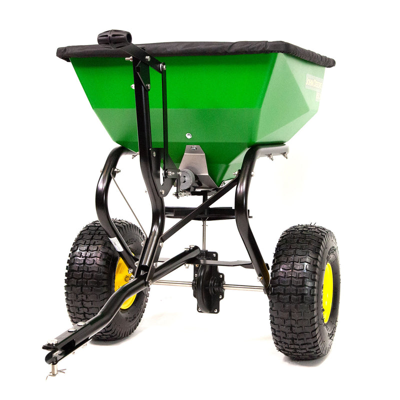 The John Deere 150 lb Tow-Behind Broadcast Spreader with ACCUWAY (LP79931) ensures pro-level durability with its 150lb capacity. This green spreader, featuring a black metal frame, large textured wheels, and a hopper cover, excels at dispersing seed or fertilizer on lawns efficiently.