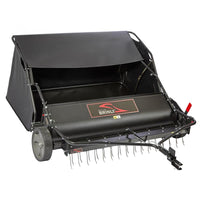 The Brinly Parts 54″ Combo Lawn Sweeper with Dethatcher (LSDT2-54BH-G) features a wide collection hopper, sturdy wheels, and metal tines for effective turf maintenance. The Brinly brand is displayed on the front.