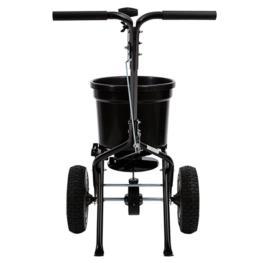 A front view of the Brinly Parts 50 LB. Push Spreader with Deflector Kit (P20-500BHDF), featuring a container for seeds or fertilizer, two large textured wheels, a top handlebar, and a metal frame for support.