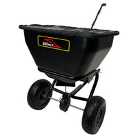 A black Brinly Parts 175 LB. Tow-Behind Deluxe Spreader (BS361BH-A) features an extended handle, large wheels, and a fabric cover. Its rust-proof polyethylene hopper efficiently spreads seed or fertilizer.