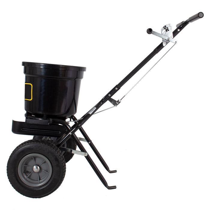 The Brinly Parts 50 LB. Push Spreader with Side Deflector & Hopper Cover (P20-500BHDF-A) features a durable metal frame, large hopper, adjustable handle, and two wheels for even seed or fertilizer distribution on your lawn.