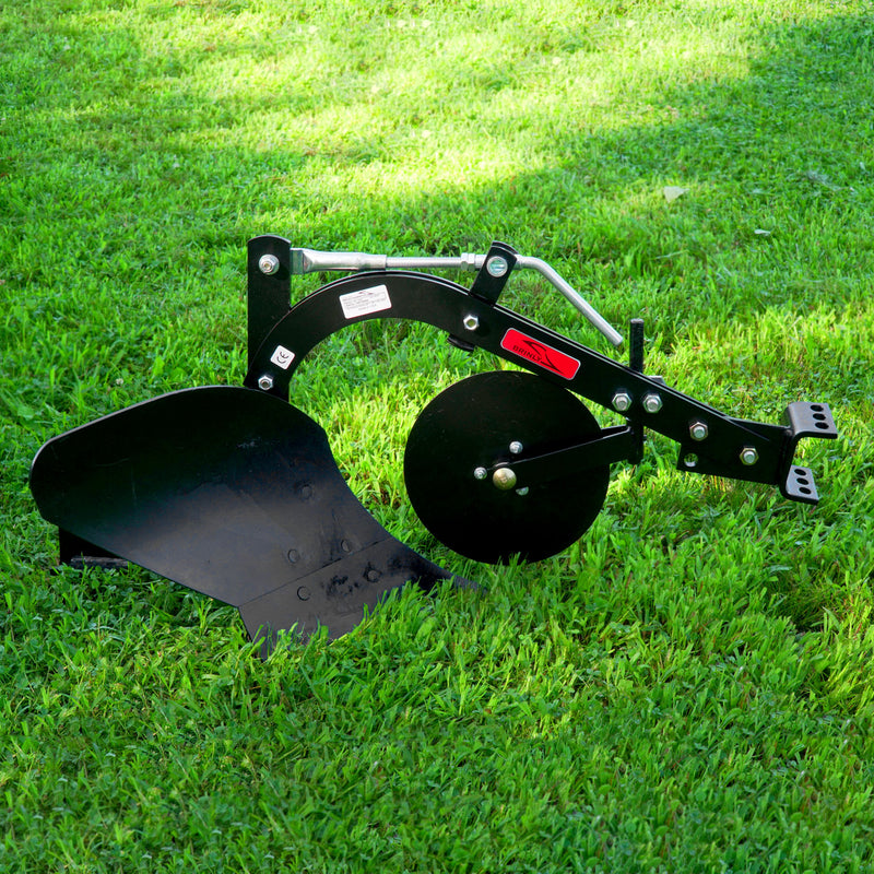 The Brinly Parts Sleeve Hitch Moldboard Plow | PP-510, with its curved blade and disc, rests on green grass. Its metal arms signal its a tractor attachment. The sunlit lawn backdrop perfectly highlights its robust design.