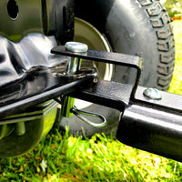 Close-up of the Brinly Parts 40″ Tow-Behind Spike Aerator (SA2-40BH-G) hitch connection, secured by bolt and pin. A wheel and grass appear in the background, showcasing this equipment’s design for lawn aeration.
